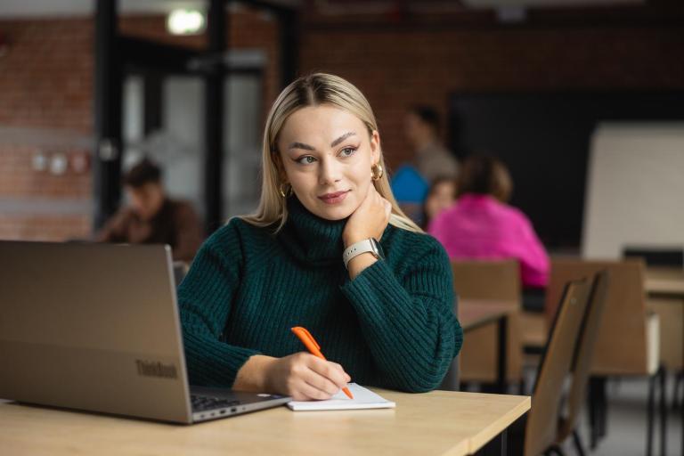 Cyfrowy uniwersytet | Uniwersytet WSB Merito w Poznaniu: Główna grafika: Poznań – studia I stopnia/cyfrowy uniwersytet – studentka z notatkami i laptopem