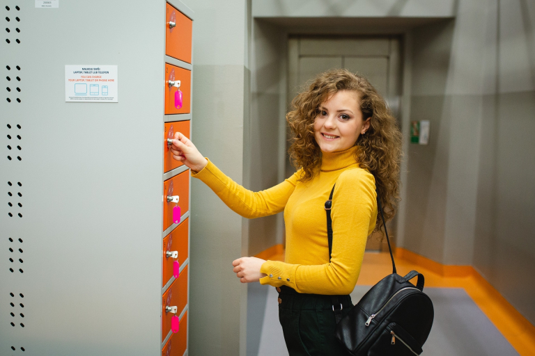FOR UKRAINE Programme for Scientists from Ukraine Cooperating with Scientists from Poland | Uniwersytet WSB Merito w Poznaniu: dziewczyna otwiera szafkę na klucz na uczelni