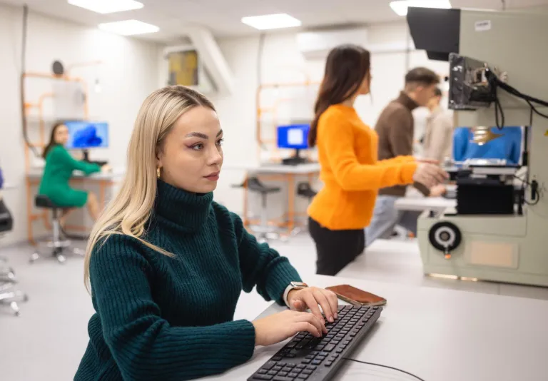 Zarządzanie Bezpieczeństwem | Uniwersytet WSB Merito w Poznaniu: Studentka pracuje przy komputerze w nowoczesnym laboratorium