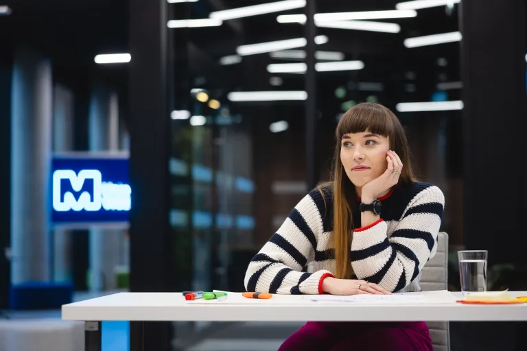 Główna grafika: Poznań - studia podyplomowe - Uczestniczka studiów podyplomowych podczas sesji zdjęciowej w tle logo Merito