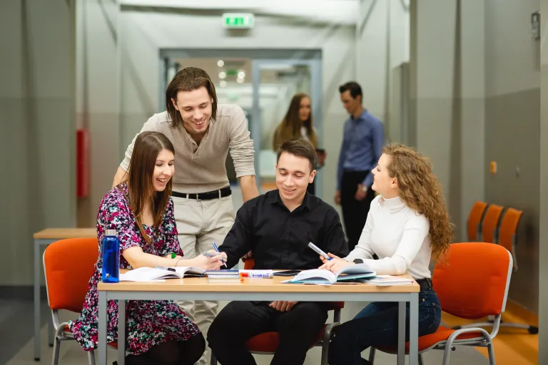 Finanse i rachunkowość | Studia II stopnia ze studiami podyplomowymi w Poznaniu | Uniwersytet WSB Merito w Poznaniu: Grupa studentów pracuje przy stole