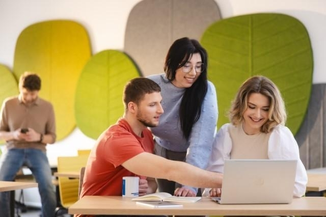 Университет ВСБ Мерито в Щецине | Университеты ВСБ Мерито: Studenci Uniwersytetu WSB Merito pracujący wspólnie przy laptopie w przestrzeni studenckiej.