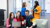 Logistyka w przedsiębiorstwie | Studia I stopnia w Szczecinie | Uniwersytet WSB Merito Szczecin: Studenci spędzają czas w strefie relaksu, rozmawiając i pracując na laptopie.