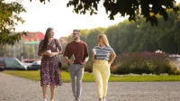 Neuropsychologia | Studia jednolite magisterskie w Szczecinie | Uniwersytet WSB Merito Szczecin: Troje studentów Uniwersytetu WSB Merito Szczecin spaceruje po parku, trzymając kawę i rozmawiając.
