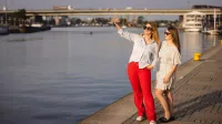 ESG – menedżer ds. zrównoważonego rozwoju | Uniwersytet WSB Merito Szczecin: Dwie studentki Uniwersytetu WSB Merito Szczecin robią selfie nad Odrą w słoneczny dzień.