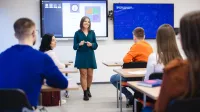 Sztuczna inteligencja w biznesie | Studia podyplomowe w Szczecinie | Uniwersytet WSB Merito Szczecin: Studentka Uniwersytetu WSB Merito prowadzi prezentację w sali wykładowej, a pozostali studenci słuchają jej wystąpienia.