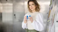 Nowoczesne technologie i usługi dla biznesu | Uniwersytet WSB Merito Szczecin: Studentka Uniwersytetu WSB Merito Szczecin z kubkiem kawy przy tablicy.