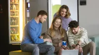 Cyfryzacja, współpraca i bezpieczeństwo pracy – praktyczne kompetencje specjalistów Publicznych Służb Zatrudnienia | Uniwersytet WSB Merito Szczecin: Czworo studentów Uniwersytetu WSB Merito siedzi w strefie relaksu, pracując wspólnie przy laptopie.
