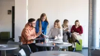 Psychologia reklamy i komunikacji | Studia podyplomowe w Szczecinie | Uniwersytet WSB Merito Szczecin: grupa studentów na korytarzu na Uczelni WSB Merito Szczecin