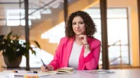 Studia menedżerskie | Studia podyplomowe w Szczecinie | Uniwersytet WSB Merito Szczecin: studentka przy biurku na uczelni WSB Merito Szczecin