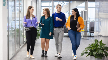 Dydaktyka języków obcych | Studia podyplomowe w Szczecinie | Uniwersytet WSB Merito Szczecin: Studenci rozmawiają spacerując korytarzem podczas przerwy.