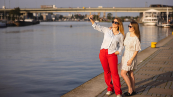 ESG – menedżer ds. zrównoważonego rozwoju | Studia podyplomowe w Szczecinie | Uniwersytet WSB Merito Szczecin: Dwie studentki Uniwersytetu WSB Merito Szczecin robią selfie nad Odrą w słoneczny dzień.
