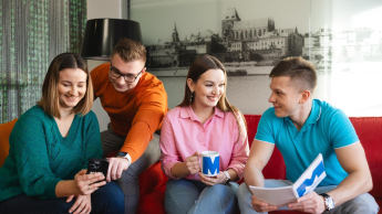 Zarządzanie produkcją | Studia podyplomowe w Szczecinie | Uniwersytet WSB Merito Szczecin: Studenci WSB Merito rozmawiają i przeglądają materiały.