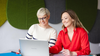 SAP S/4HANA – nowoczesny system ERP | Studia podyplomowe w Szczecinie | Uniwersytet WSB Merito Szczecin: Dwie kobiety pracują przy laptopie, uśmiechając się i omawiając materiały.