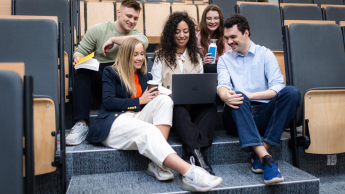 Zarządzanie | Studia II stopnia w Szczecinie | Uniwersytet WSB Merito Szczecin: Studenci pracują zespołowo przy laptopie w auli wykładowej.