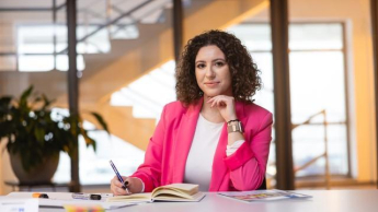 Studia menedżerskie | Studia podyplomowe w Szczecinie | Uniwersytet WSB Merito Szczecin: studentka przy biurku na uczelni WSB Merito Szczecin