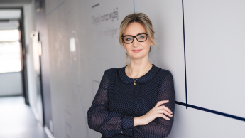 MBA Zarządzanie w podmiotach leczniczych | Studia MBA w Szczecinie | Uniwersytet WSB Merito Szczecin: Uczestniczka studiów MBA opiera się o ścianę na korytarzu uczelni- Uniwersytet WSB Merito w Szczecinie 