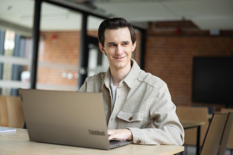 Cyfrowy uniwersytet | Uniwersytet WSB Merito Szczecin: Student Uniwersytetu WSB Merito pracujący przy laptopie