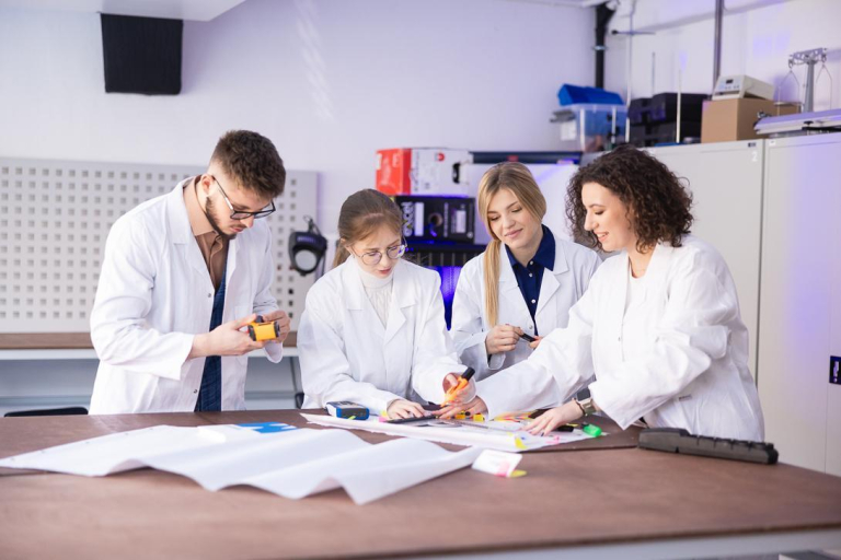 Leczenie otyłości | Studia podyplomowe w Szczecinie | Uniwersytet WSB Merito Szczecin: Grupa studentów w fartuchach w sali laboratoryjnej