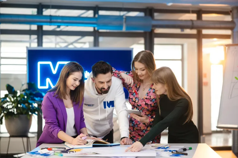 Marketing i sprzedaż | Studia I stopnia w Szczecinie | Uniwersytet WSB Merito Szczecin: Czworo studentów Uniwersytetu WSB Merito wspólnie pracuje nad projektem przy tablecie.