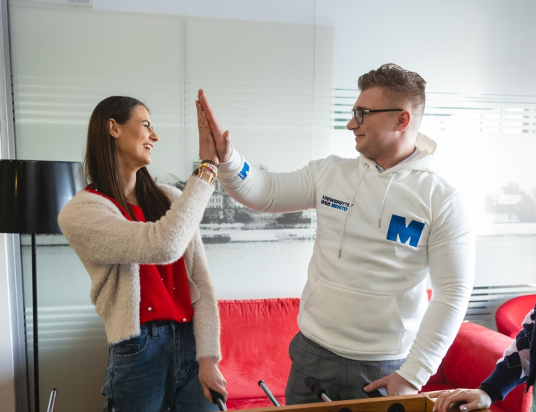 Strona główna | Uniwersytet WSB Merito w Toruniu: Główna grafika: Toruń - studia I stopnia - grupa uśmiechniętych studentów przybijająca piątke