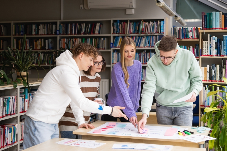 Strefa studenta | Uniwersytet WSB Merito w Toruniu: Główna grafika: Toruń - studia I stopnia - grupa uśmiechniętych studentów podczas projektu