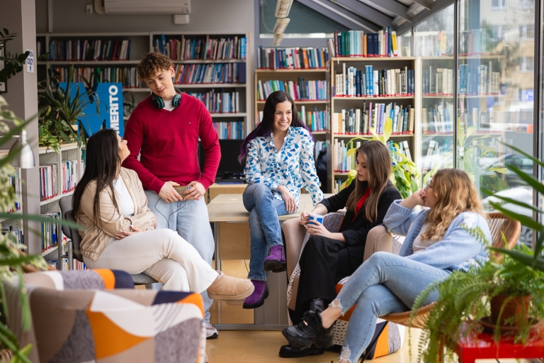 Uczelnia bez barier | Uniwersytet WSB Merito w Toruniu: Główna grafika: Toruń - studia I stopnia - grupa uśmiechniętych studentów w bibliotece