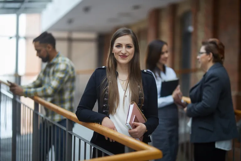 Psychologia w HR | Studia I stopnia w Toruniu | Uniwersytet WSB Merito w Toruniu: studentka a w tle grupa studentów   