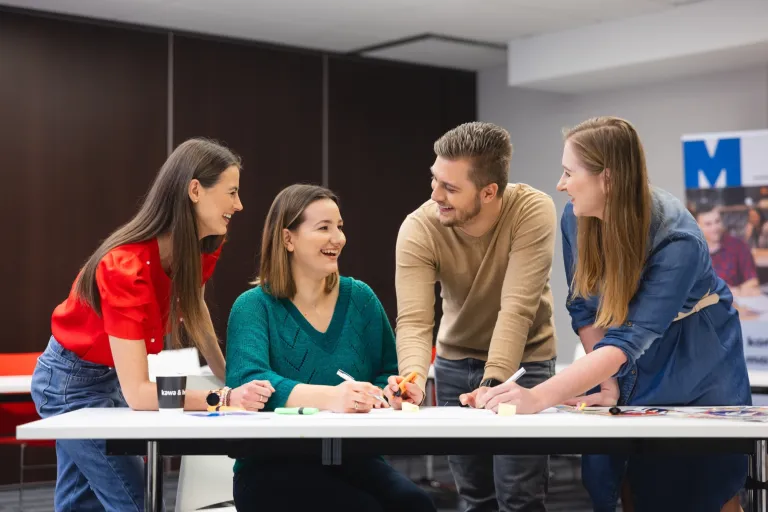 Bankowość i finanse cyfrowe | Studia II stopnia w Toruniu | Uniwersytet WSB Merito w Toruniu: Główna grafika: Toruń - studia I stopnia - grupa uśmiechniętych studentów podczas projektu