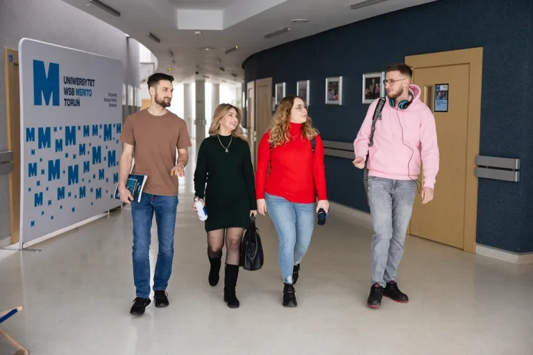 Informatyka w biznesie | Studia II stopnia w Toruniu | Uniwersytet WSB Merito w Toruniu: Główna grafika: Toruń - studia I stopnia - grupa uśmiechniętych studentów w korytarzu