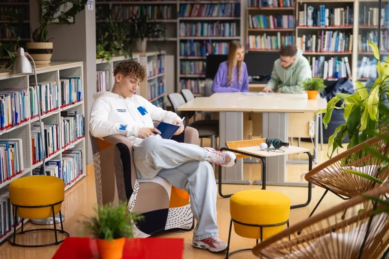 Kadry i płace | Studia II stopnia ze studiami podyplomowymi  | Uniwersytet WSB Merito w Toruniu: Główna grafika: Toruń - studia I stopnia - grupa studentów w bibliotece