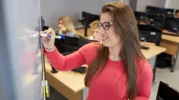 Inżynieria baz danych | Studia I stopnia w Warszawie | Uniwersytet WSB Merito Warszawa: Studentka przy tablicy w sali komputerowej