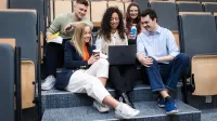 Zarządzanie przedsiębiorstwem | Studia I stopnia w Warszawie | Uniwersytet WSB Merito Warszawa: Grupa studentów siedzących na schodach 