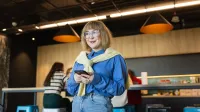 Marketing i sprzedaż | Studia II stopnia w Warszawie | Uniwersytet WSB Merito Warszawa: Studentka w okularach z telefonem