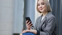 Sztuczna inteligencja w komunikacji biznesowej | Studia II stopnia w Warszawie | Uniwersytet WSB Merito Warszawa: Studentka z telefonem