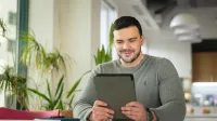 Tworzenie aplikacji internetowych i mobilnych | Studia podyplomowe w Warszawie | Uniwersytet WSB Merito Warszawa: mężczyzna pracujący z tabletem