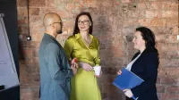 Dydaktyka języków obcych | Studia podyplomowe w Warszawie | Uniwersytet WSB Merito Warszawa: trzy osoby podczas rozmowy