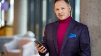 Controlling w biznesie | Studia podyplomowe w Warszawie | Uniwersytet WSB Merito Warszawa: mężczyzna trzymający telefon w ręce