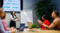 Inżynieria oprogramowania w JavaScript (TypeScript) | Studia podyplomowe w Warszawie | Uniwersytet WSB Merito Warszawa: grupa ludzi słuchająca przedstawienia projektu