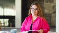 Akademia Lidera Merito | Szkolenia i kursy w Warszawie | Uniwersytet WSB Merito Warszawa: Studentka siedzi przy stole.