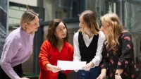 Organizacja eventów  - MICE | Studia I stopnia w Warszawie | Uniwersytet WSB Merito Warszawa: Ludzie omawiają projekt nad stołem.