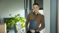Employer Branding | Studia podyplomowe w Warszawie | Uniwersytet WSB Merito Warszawa: Student WSB Merito trzyma dyplom w ręce z uśmiechem na twarzy