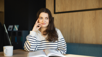 Ekonomia | Studia II stopnia w Warszawie | Uniwersytet WSB Merito Warszawa: studentka z książką 