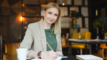 Administracja – prawo, zarządzanie i organizacja | Studia podyplomowe w Warszawie | Uniwersytet WSB Merito Warszawa: uśmiechnięta kobieta notująca notatki