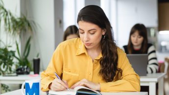 Ekonomia | Studia II stopnia ze studiami podyplomowymi w Warszawie | Uniwersytet WSB Merito Warszawa: studentka z książką 