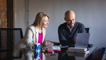International HR operations and Payroll | Studia podyplomowe w Warszawie | Uniwersytet WSB Merito Warszawa: kobieta i mężczyzna patrzący w ekran laptopa