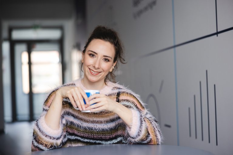 Wczesne wspomaganie rozwoju | Studia podyplomowe w Warszawie | Uniwersytet WSB Merito Warszawa: uśmiechnięta kobieta trzymająca kubek w rękach