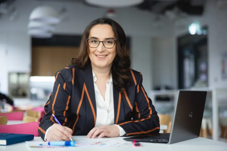Logistyka międzynarodowa | Studia II stopnia w Warszawie | Uniwersytet WSB Merito Warszawa: Siedząca kobieta przy biurku
