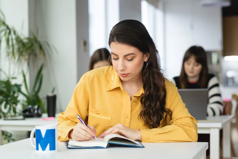 Biznes międzynarodowy | Studia II stopnia ze studiami podyplomowymi  | Uniwersytet WSB Merito Warszawa: studentka z książką 