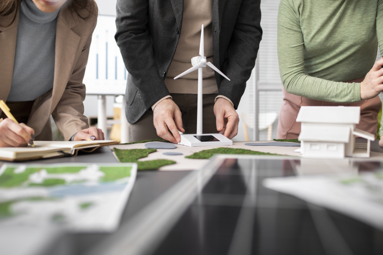 EKOnferencja 2025. Turystyka przyjazna przyrodzie | Uniwersytet WSB Merito we Wrocławiu: Grupa osób pracująca przy modelu turbiny wiatrowej